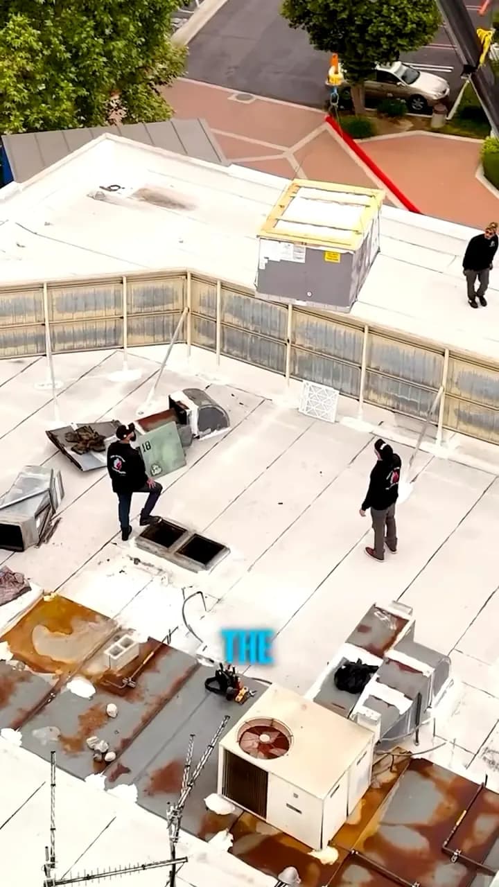 Aerial view of technicians working on rooftop HVAC equipment