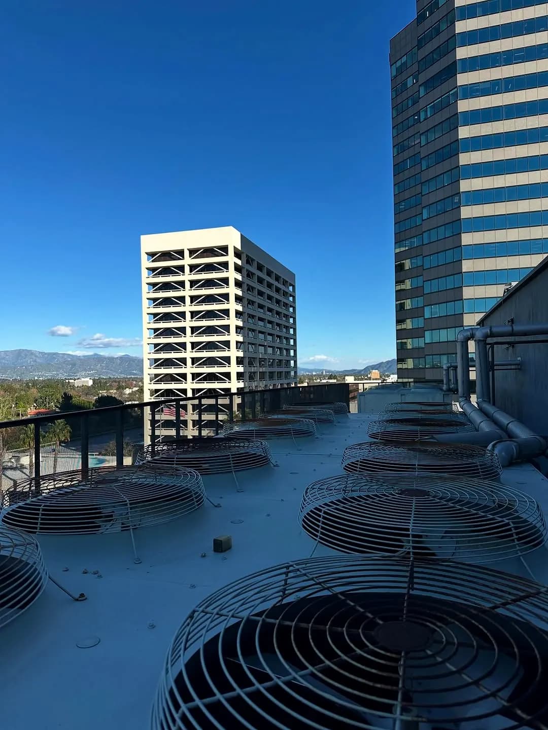 Rooftop condenser fans with city buildings in the background