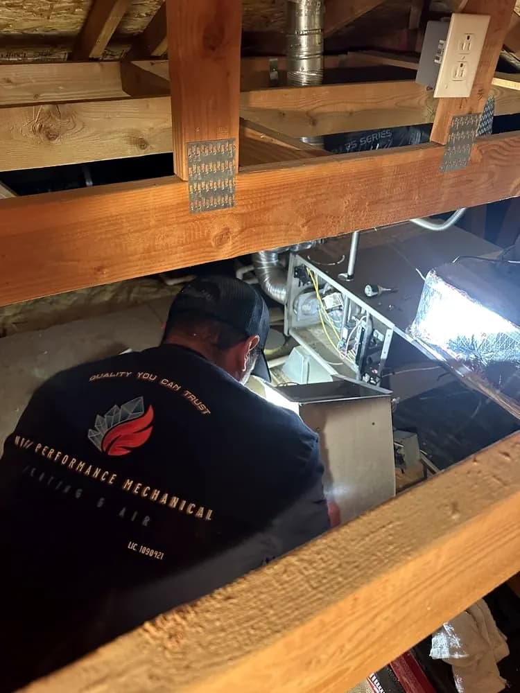 Technician working on equipment in an attic