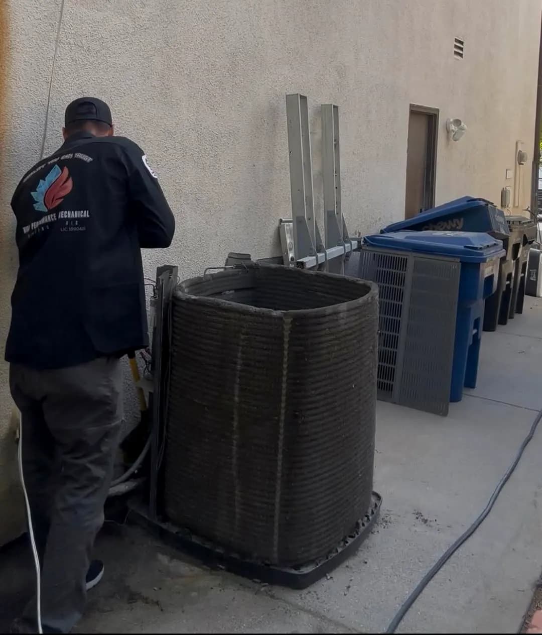 Technician beside an outdoor condenser unit