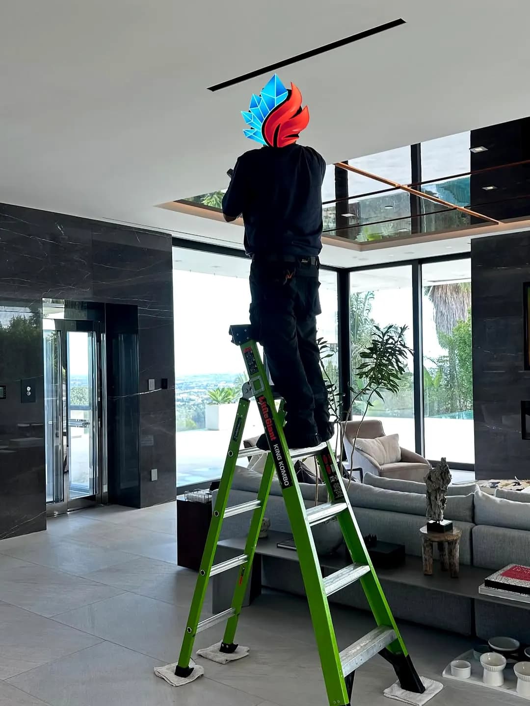 Technician on a ladder installing equipment in a modern home