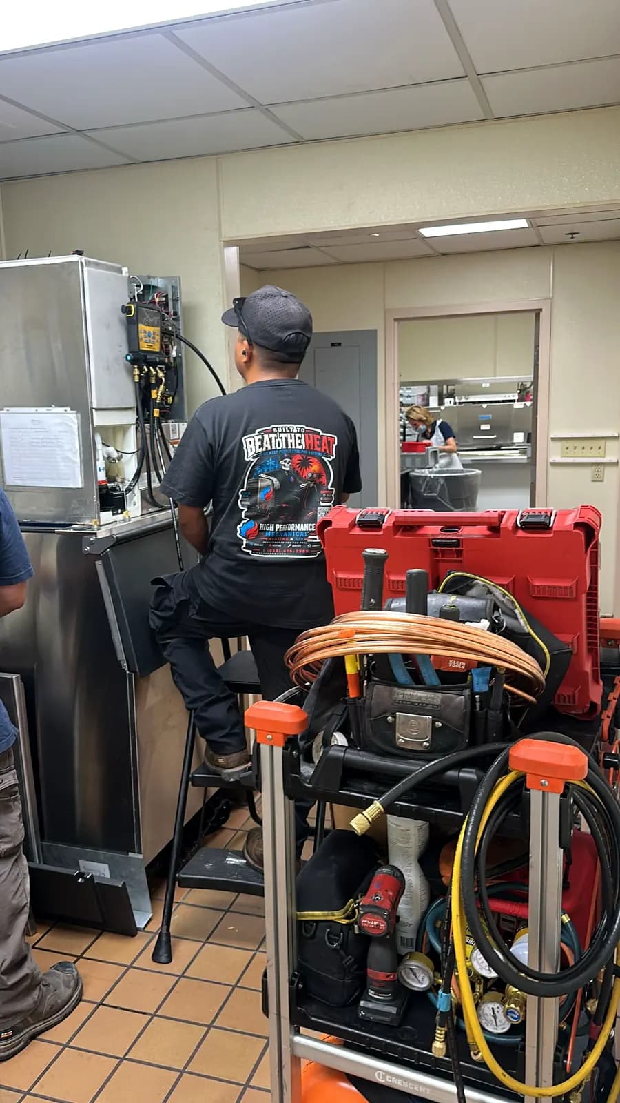 Technician with a tool cart servicing restaurant equipment
