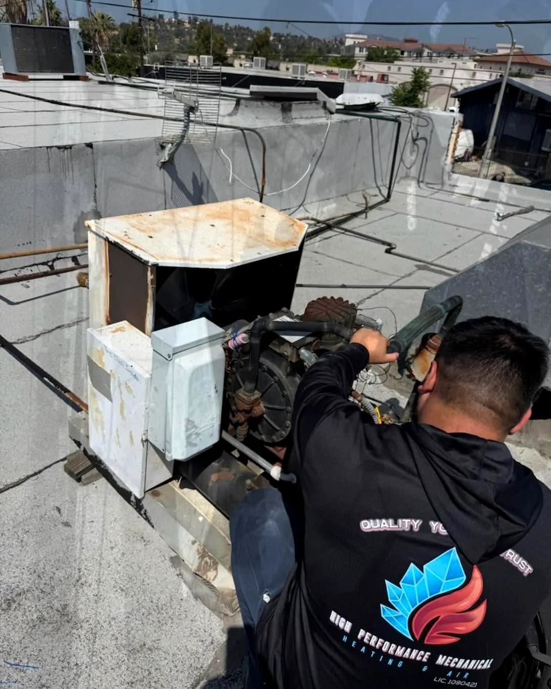 Technician repairing an older rooftop unit